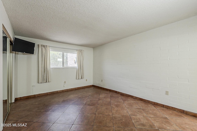 221 N Calle Del Lago, Green Valley, AZ 85614 - spare room featuring baseboards, dark tile patterned floors, and a textured ceiling