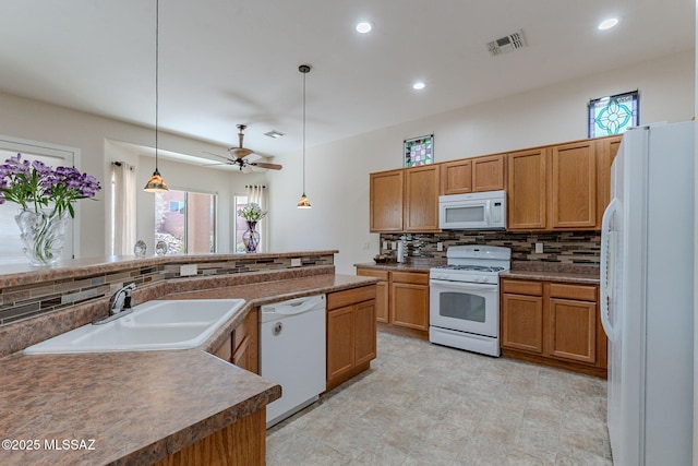 kitchen featuring a sink, visible vents, white appliances, and a healthy amount of sunlight