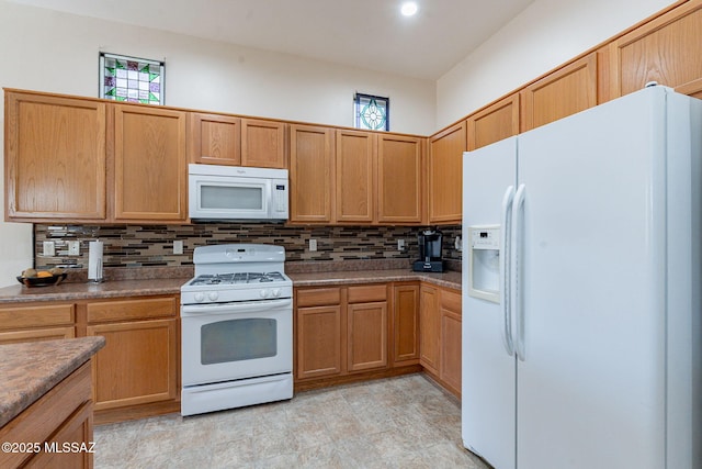 kitchen featuring decorative backsplash and white appliances