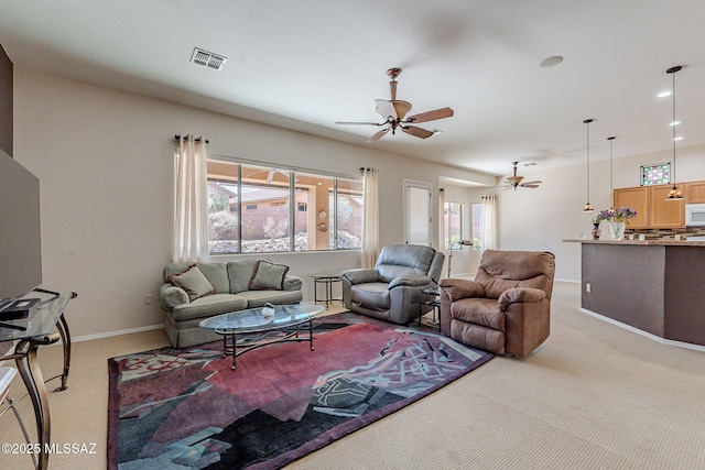 living area with light carpet, ceiling fan, visible vents, and a wealth of natural light