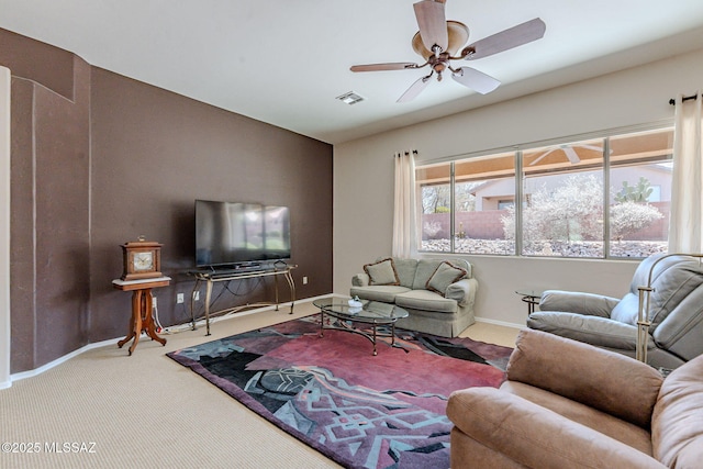 living room featuring baseboards, a ceiling fan, and carpet floors