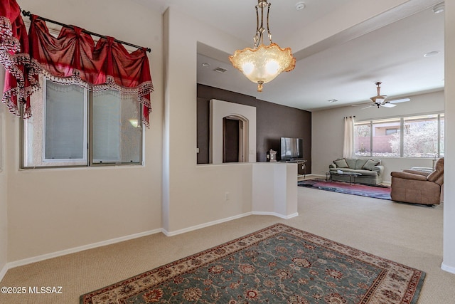interior space with visible vents, baseboards, a ceiling fan, and carpet flooring