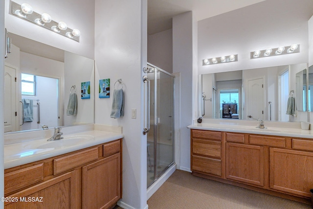 bathroom with two vanities, a sink, and a stall shower