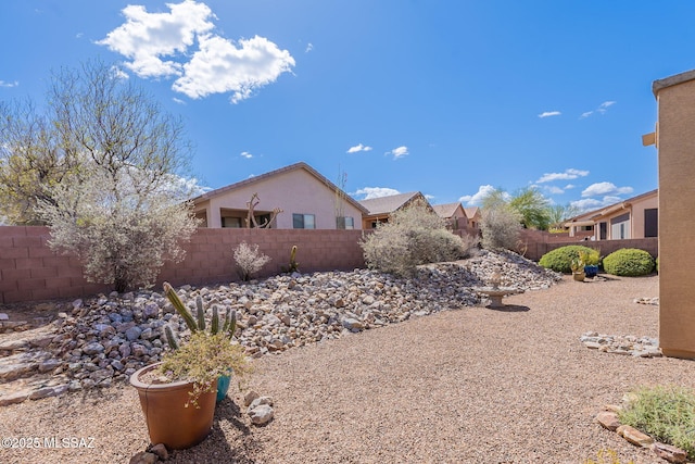 view of side of property featuring a fenced backyard and stucco siding