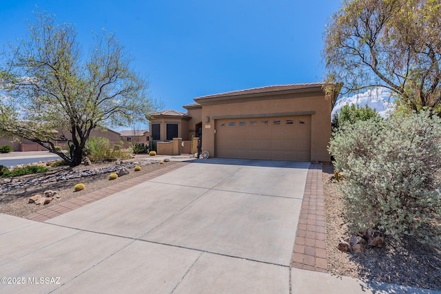view of front of home featuring a tiled roof, stucco siding, a garage, and concrete driveway