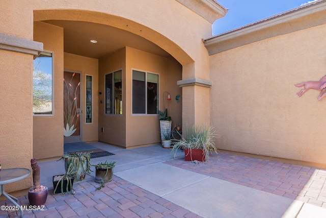 property entrance with a patio and stucco siding