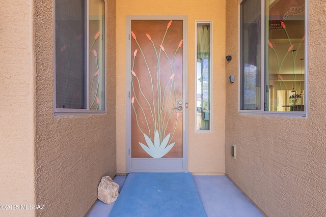 property entrance with stucco siding