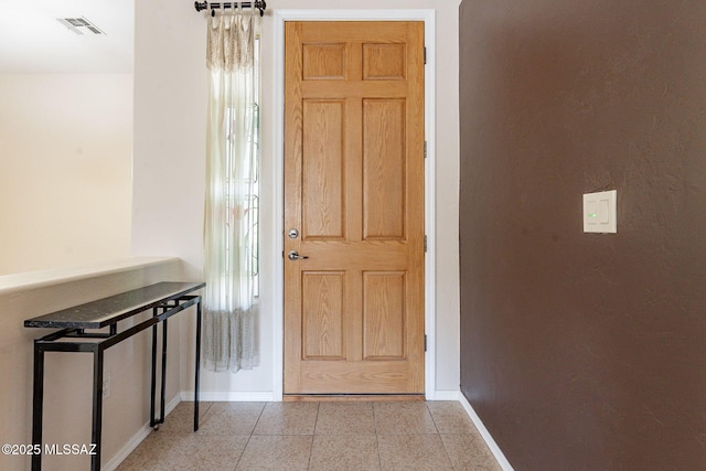 interior space with tile patterned flooring, visible vents, and baseboards