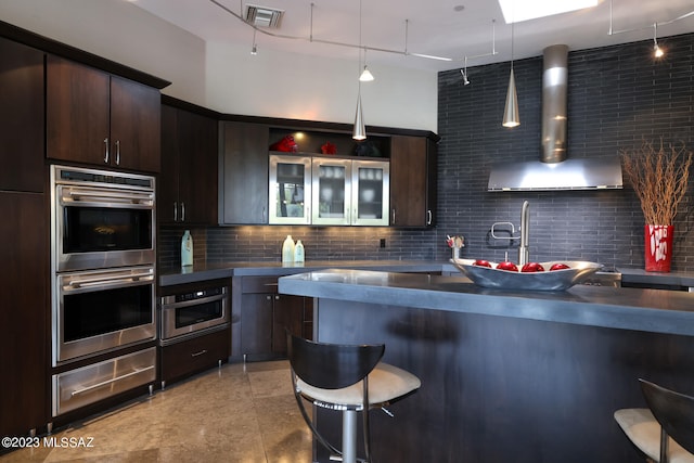 kitchen featuring decorative backsplash, dark brown cabinetry, stainless steel double oven, visible vents, and a warming drawer