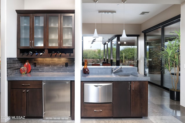 bar featuring bar, a sink, stainless steel appliances, decorative backsplash, and visible vents