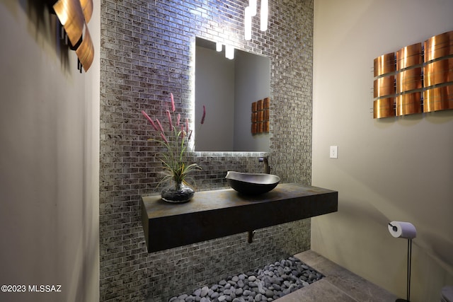 bathroom with a sink and tasteful backsplash