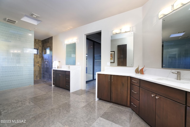 full bath featuring walk in shower, granite finish floor, visible vents, and vanity