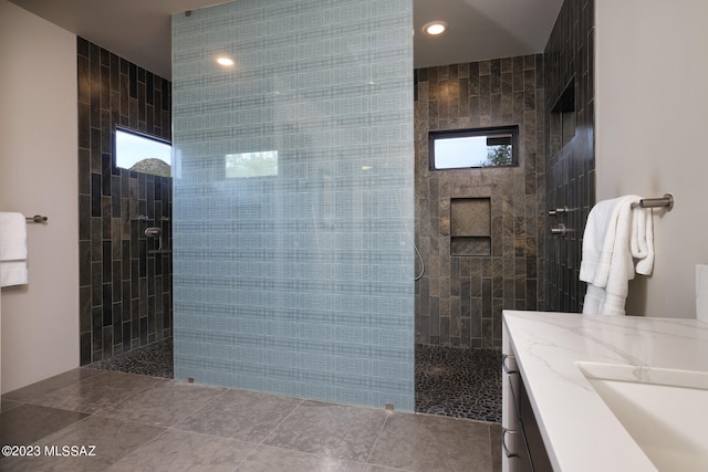 bathroom with a healthy amount of sunlight, a walk in shower, vanity, and recessed lighting