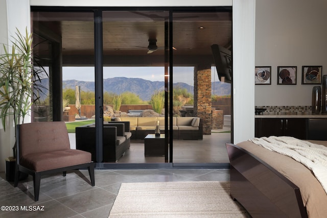 interior space with a wall of windows, tile patterned floors, and ceiling fan
