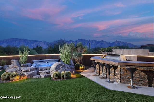 exterior space with area for grilling, a yard, a mountain view, and outdoor dry bar