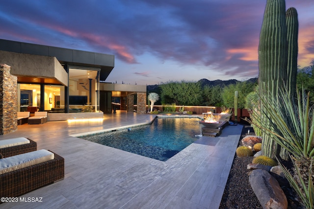 outdoor pool featuring a patio, a ceiling fan, and an outdoor living space with a fire pit