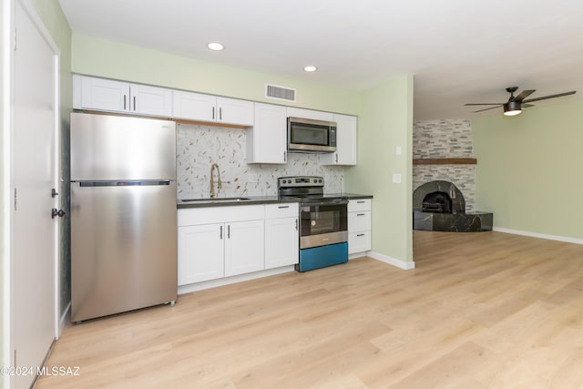 3030 N 2nd Ave, Tucson, AZ 85705 - kitchen featuring appliances with stainless steel finishes, light wood finished floors, a sink, and dark countertops