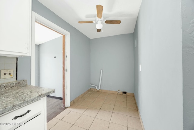 interior space featuring baseboards, light tile patterned flooring, and ceiling fan
