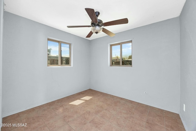 spare room with ceiling fan and a healthy amount of sunlight
