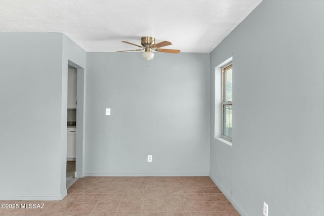 empty room with baseboards and ceiling fan