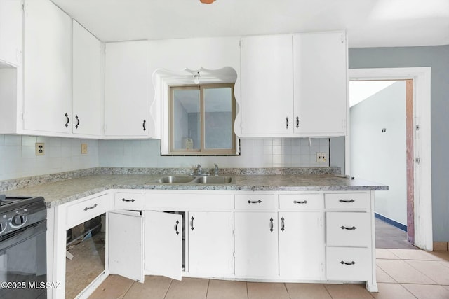 kitchen with white cabinets, a sink, light countertops, black electric range oven, and backsplash