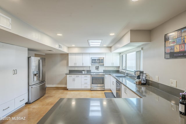 kitchen with visible vents, stainless steel counters, white cabinetry, a sink, and appliances with stainless steel finishes