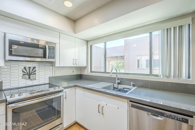 6120 E 5th St Unit B121, Tucson, AZ 85711 - kitchen with appliances with stainless steel finishes, a sink, white cabinets, and backsplash