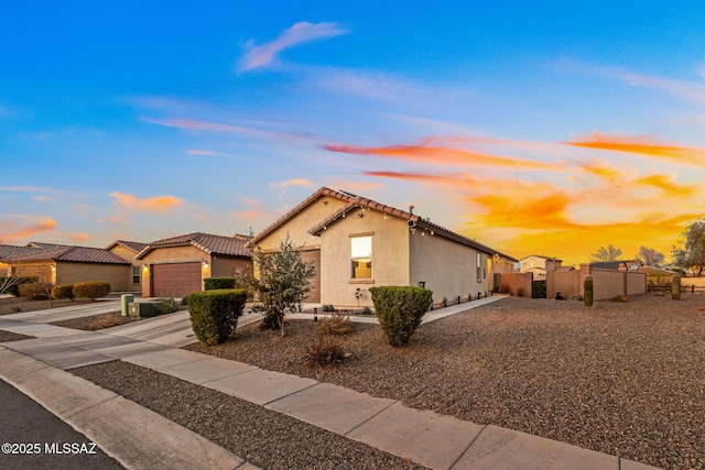 mediterranean / spanish house with concrete driveway, stucco siding, a tile roof, a garage, and fence