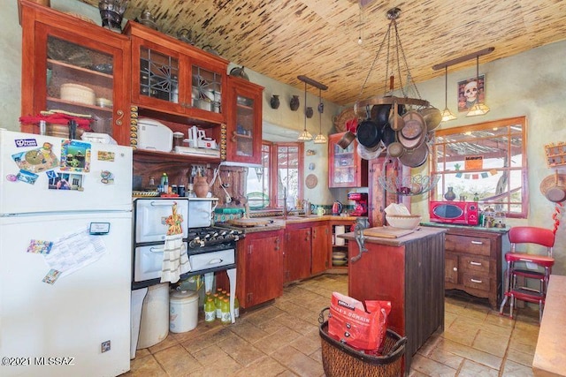 kitchen featuring a center island, glass insert cabinets, stone tile flooring, wooden ceiling, and freestanding refrigerator