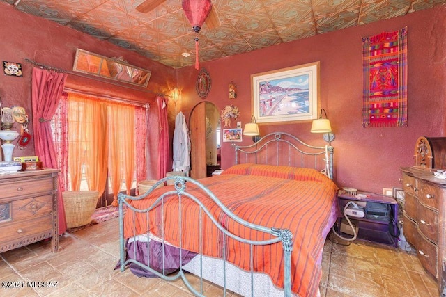 bedroom with stone finish floor and an ornate ceiling