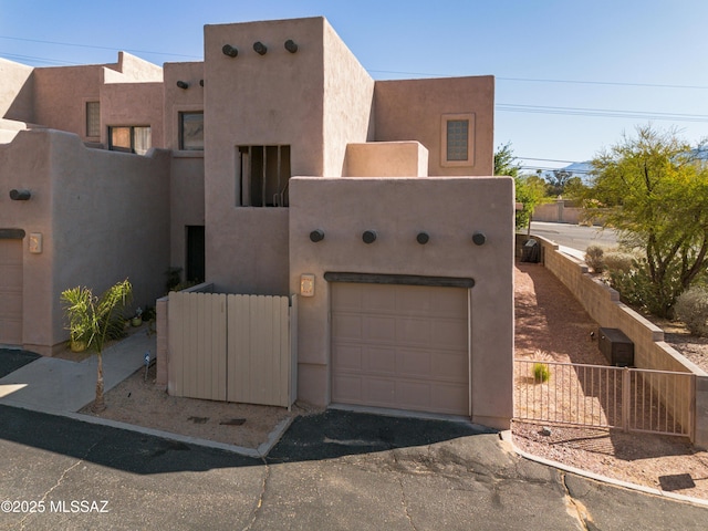 pueblo-style home with fence and stucco siding