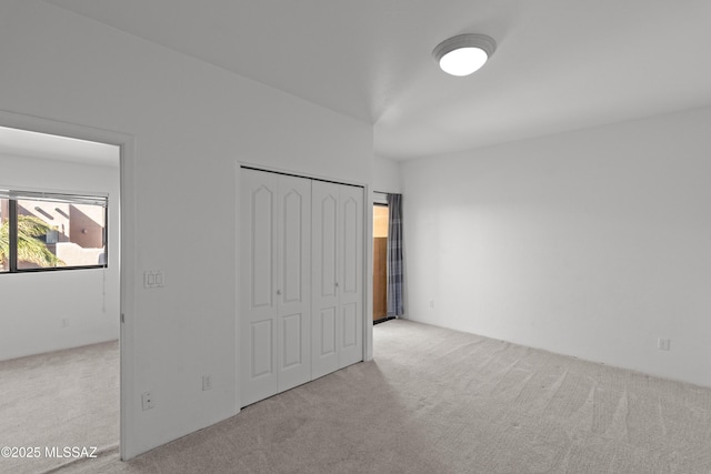 unfurnished bedroom featuring carpet floors and a closet