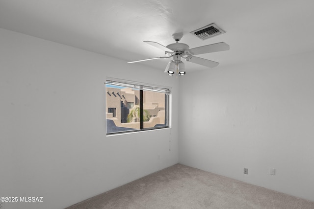 unfurnished room with carpet flooring, visible vents, and a ceiling fan