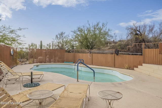 view of swimming pool featuring a pool, fence, and a patio