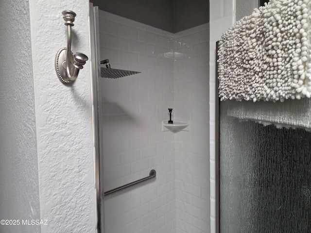 room details with a tile shower and a textured wall