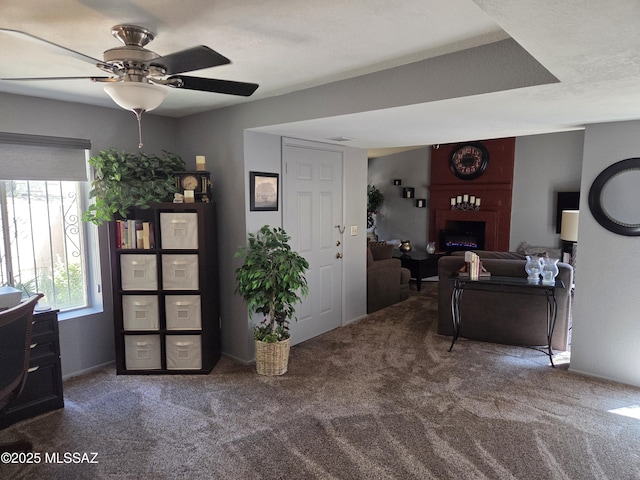 carpeted foyer entrance featuring a ceiling fan and a fireplace
