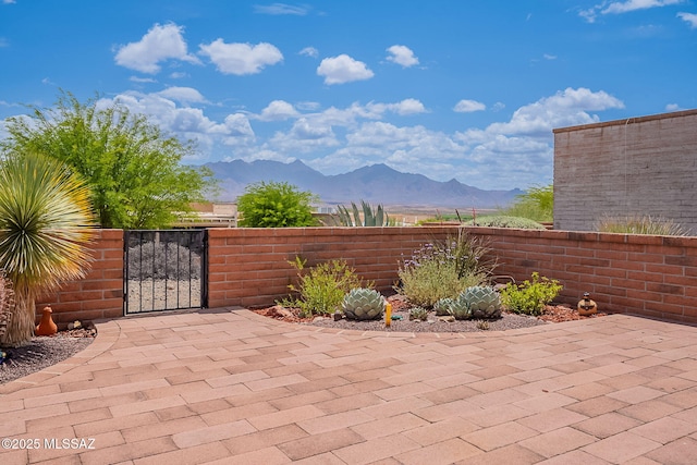view of patio / terrace with a mountain view, a gate, and fence