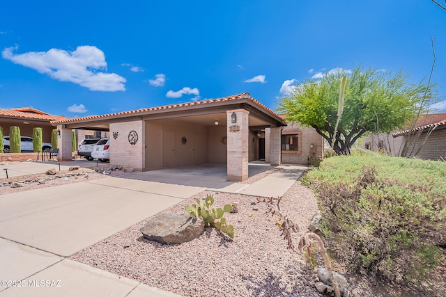3055 S Placita De La Picaza, Green Valley, AZ 85622 - view of front facade featuring a tile roof, a carport, stucco siding, driveway, and brick siding