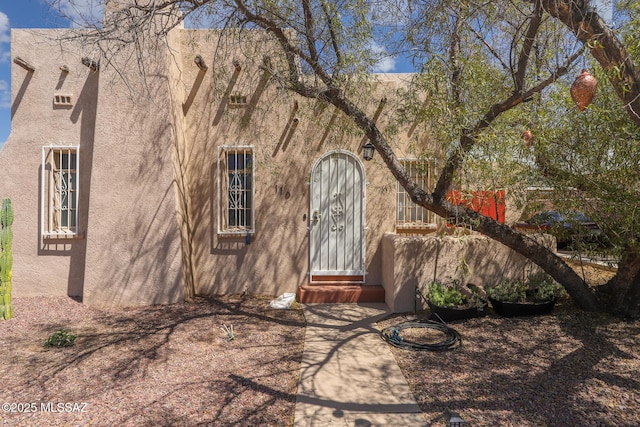 view of exterior entry featuring stucco siding