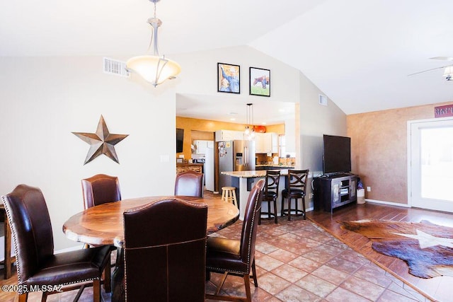 dining room featuring high vaulted ceiling, visible vents, and baseboards
