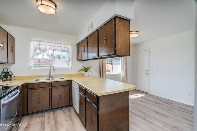 kitchen featuring a peninsula, light countertops, visible vents, white dishwasher, and a sink