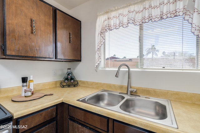kitchen featuring a sink, light countertops, and dark brown cabinetry