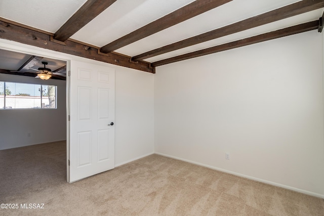 unfurnished room featuring beam ceiling, baseboards, a ceiling fan, and light carpet