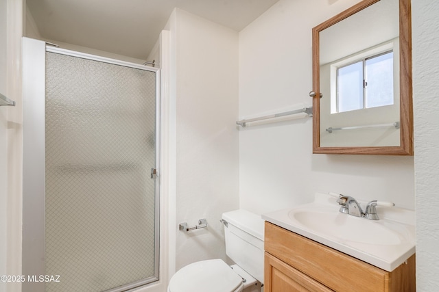bathroom featuring toilet, vanity, and a stall shower