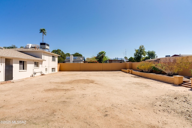 view of yard featuring central AC and a fenced backyard