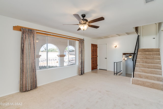 unfurnished living room with visible vents, a ceiling fan, stairway, and carpet floors
