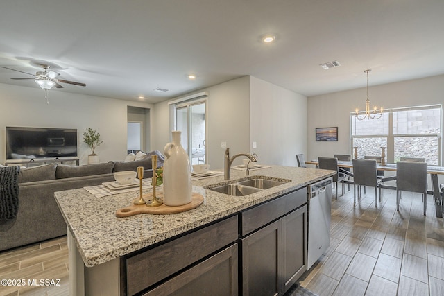1117 W Valley Meadow Ln, Sahuarita, AZ 85629 - kitchen featuring a sink, dishwasher, a chandelier, an island with sink, and light stone countertops