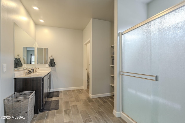 1117 W Valley Meadow Ln, Sahuarita, AZ 85629 - bathroom with vanity, a stall shower, wood finished floors, baseboards, and recessed lighting