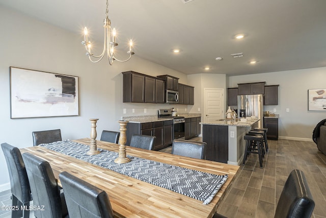 1117 W Valley Meadow Ln, Sahuarita, AZ 85629 - dining area featuring a chandelier, recessed lighting, baseboards, and wood tiled floors