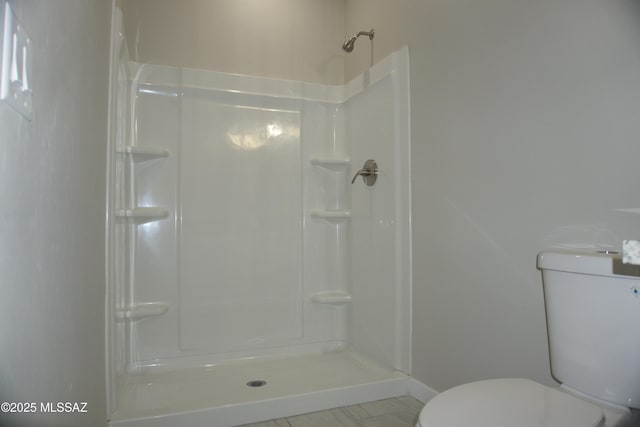 full bath with toilet, a shower, and baseboards